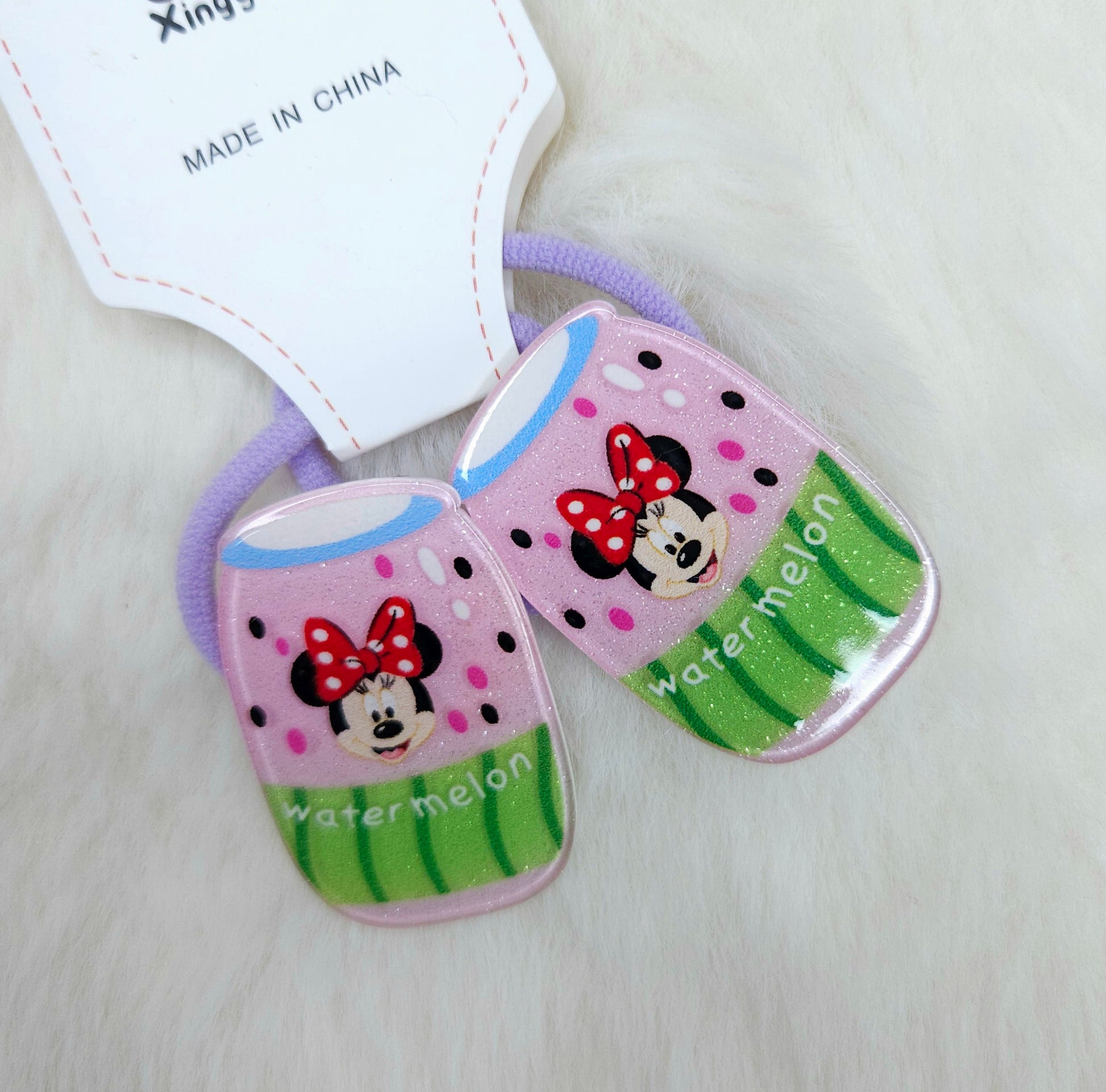 Two cartoon-themed hair ties with a watermelon design on a light background.