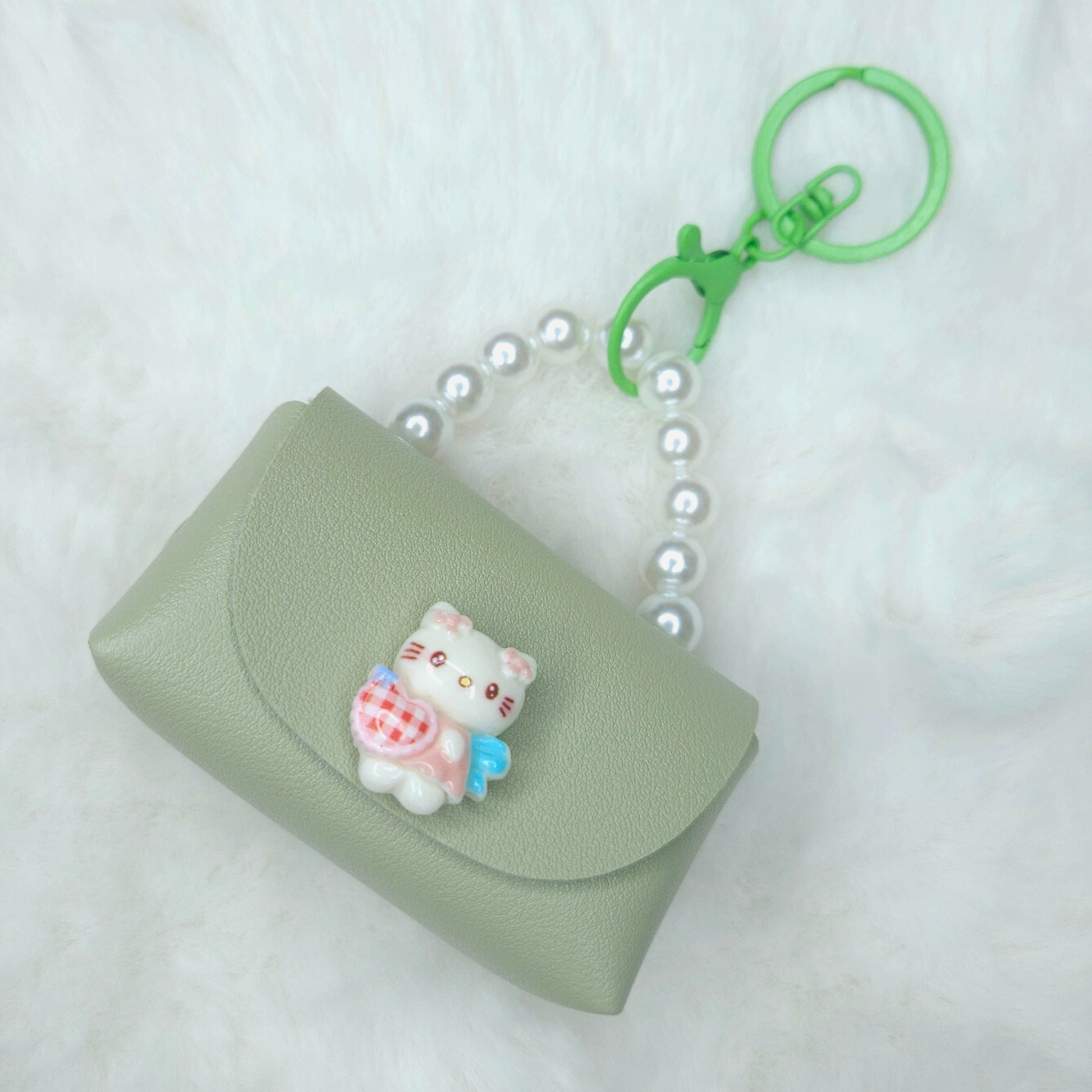 Green keychain pouch with a cat charm on a white background