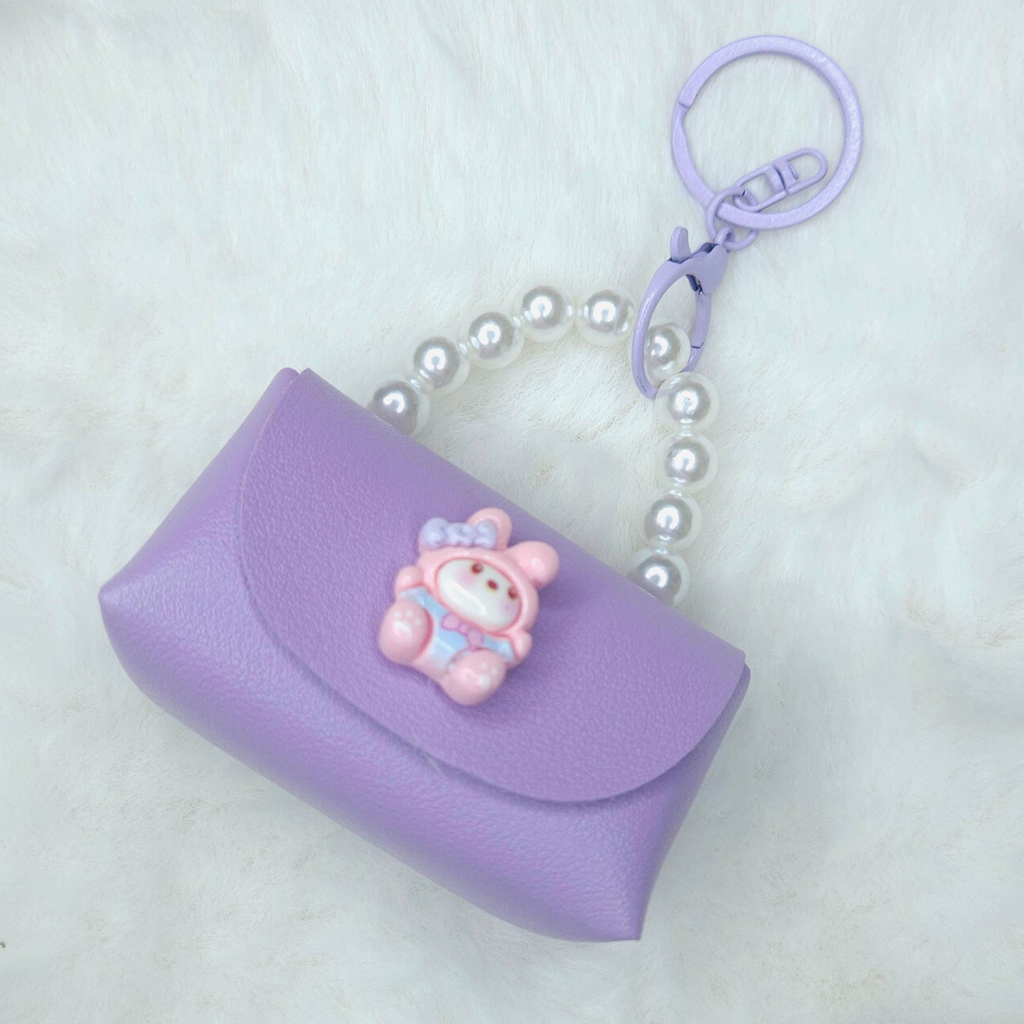 Purple keychain with a bear charm on a white background