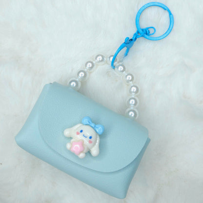 Light blue pouch with a cartoon character keychain on a white background