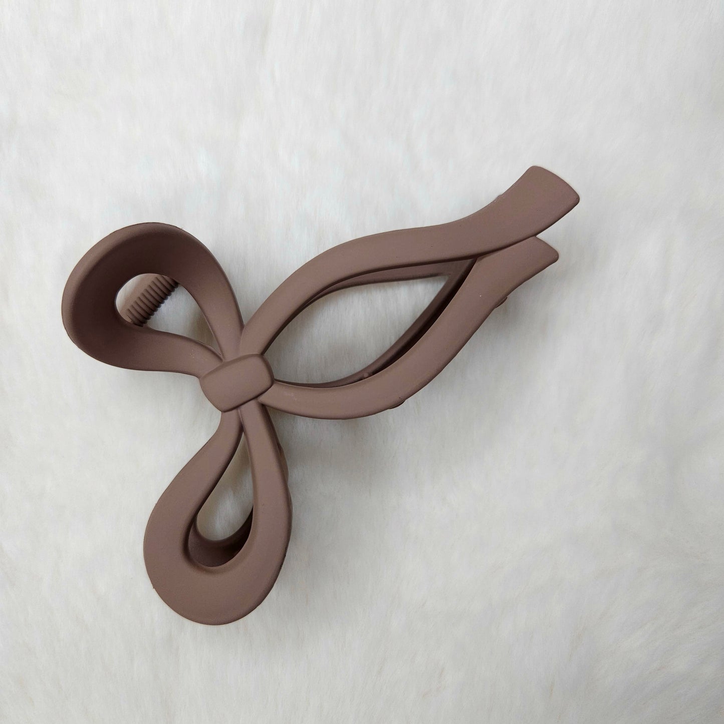 Beige color bow-shaped matte hair claw clip on a white background