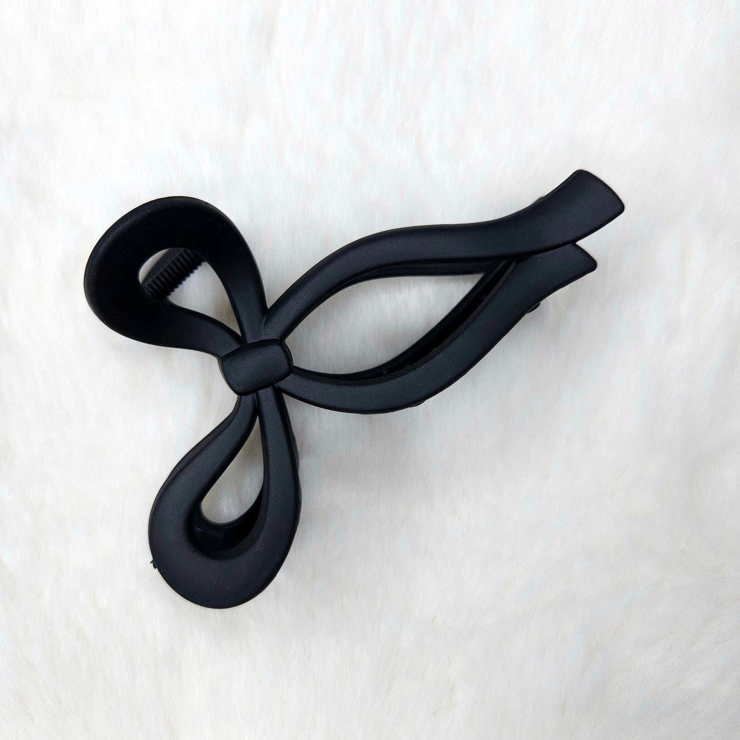 Black bow-shaped hair claw clip on a white background