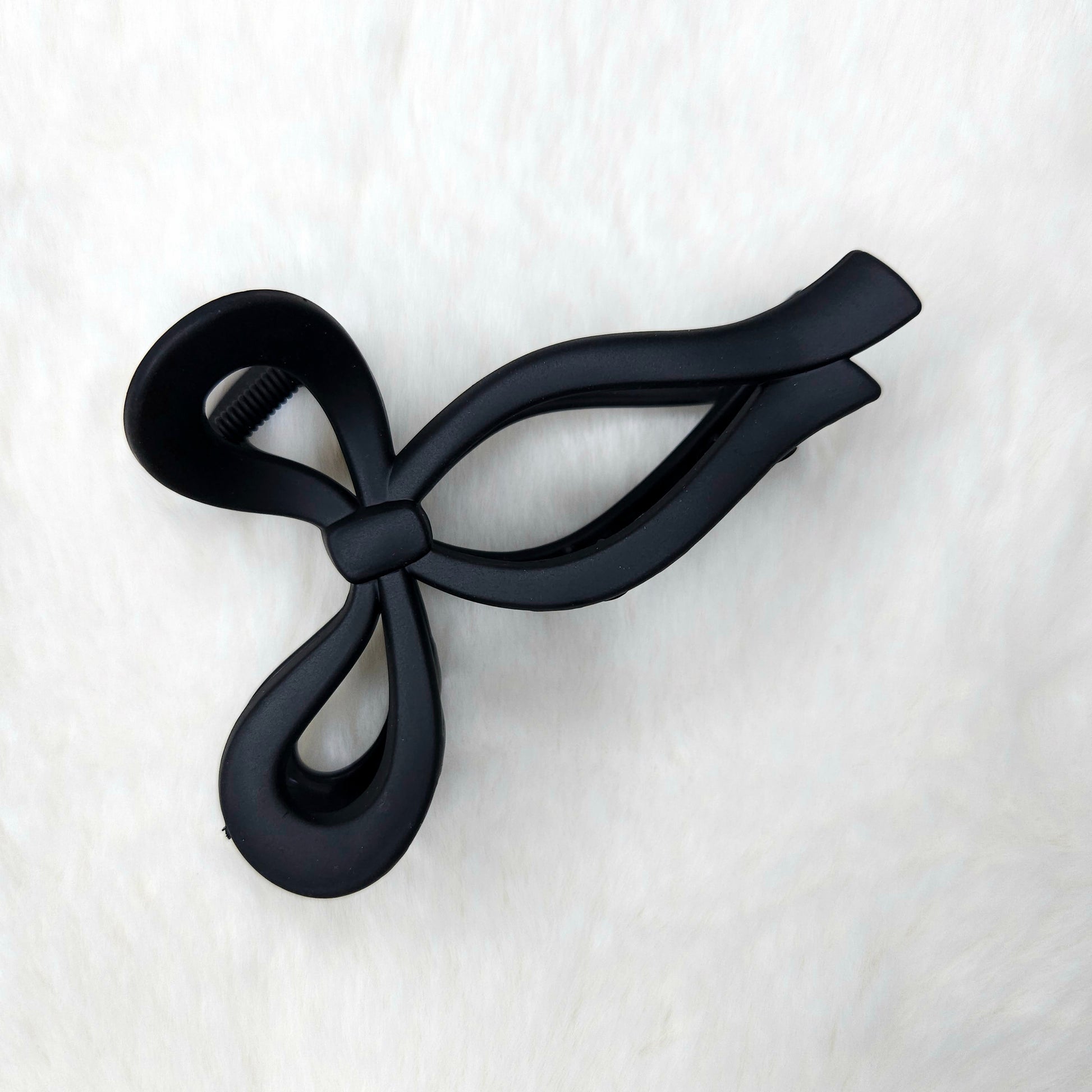 Black bow-shaped hair claw clip on a white background