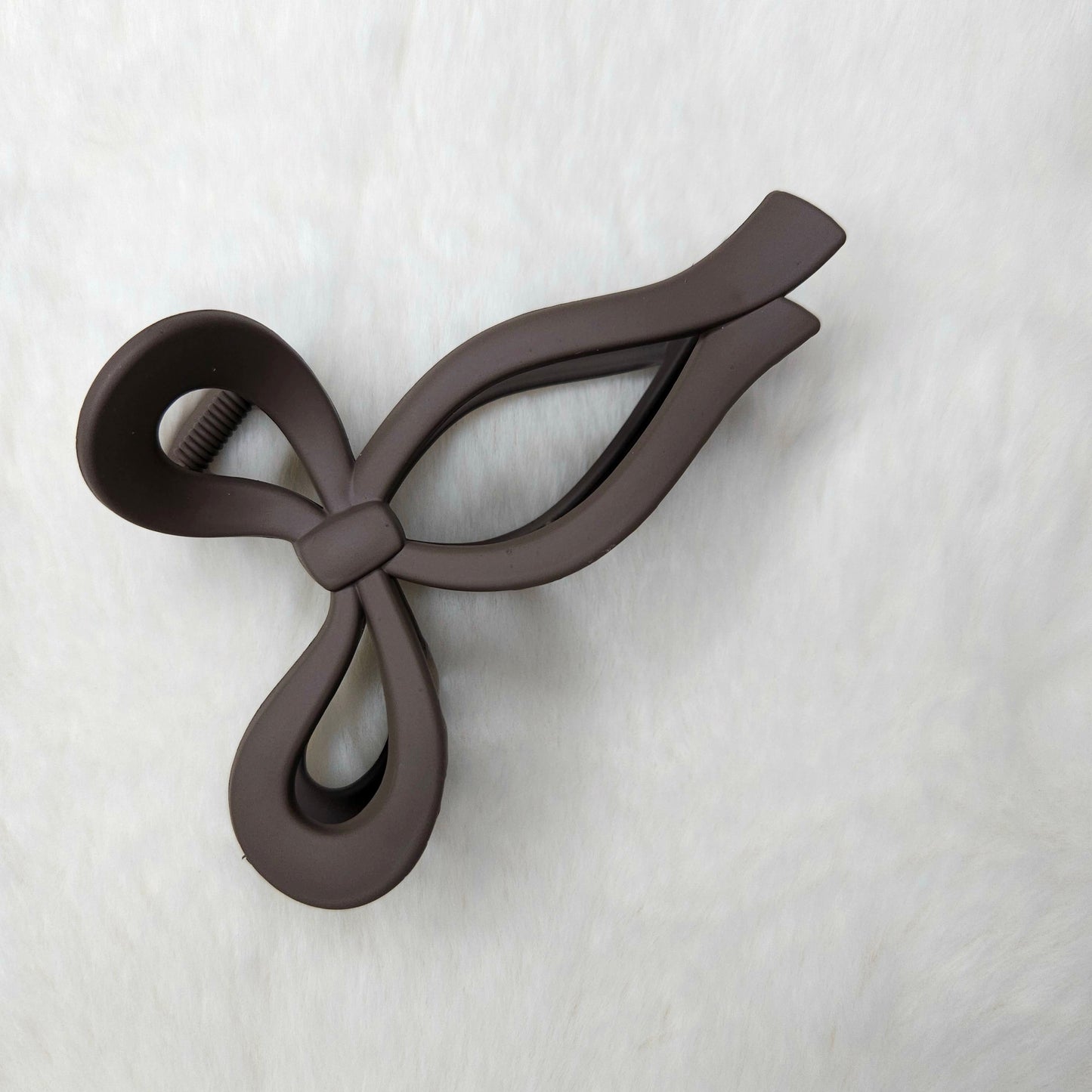 Brown color bow-shaped hair claw clip on a white background