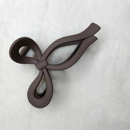Brown color bow-shaped hair claw clip on a white background