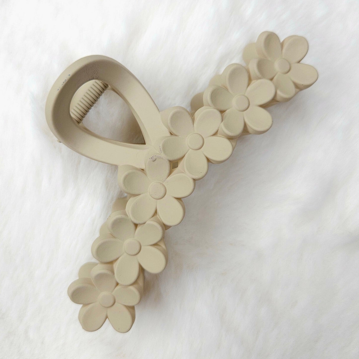 Beige hair claw with floral design on a white background