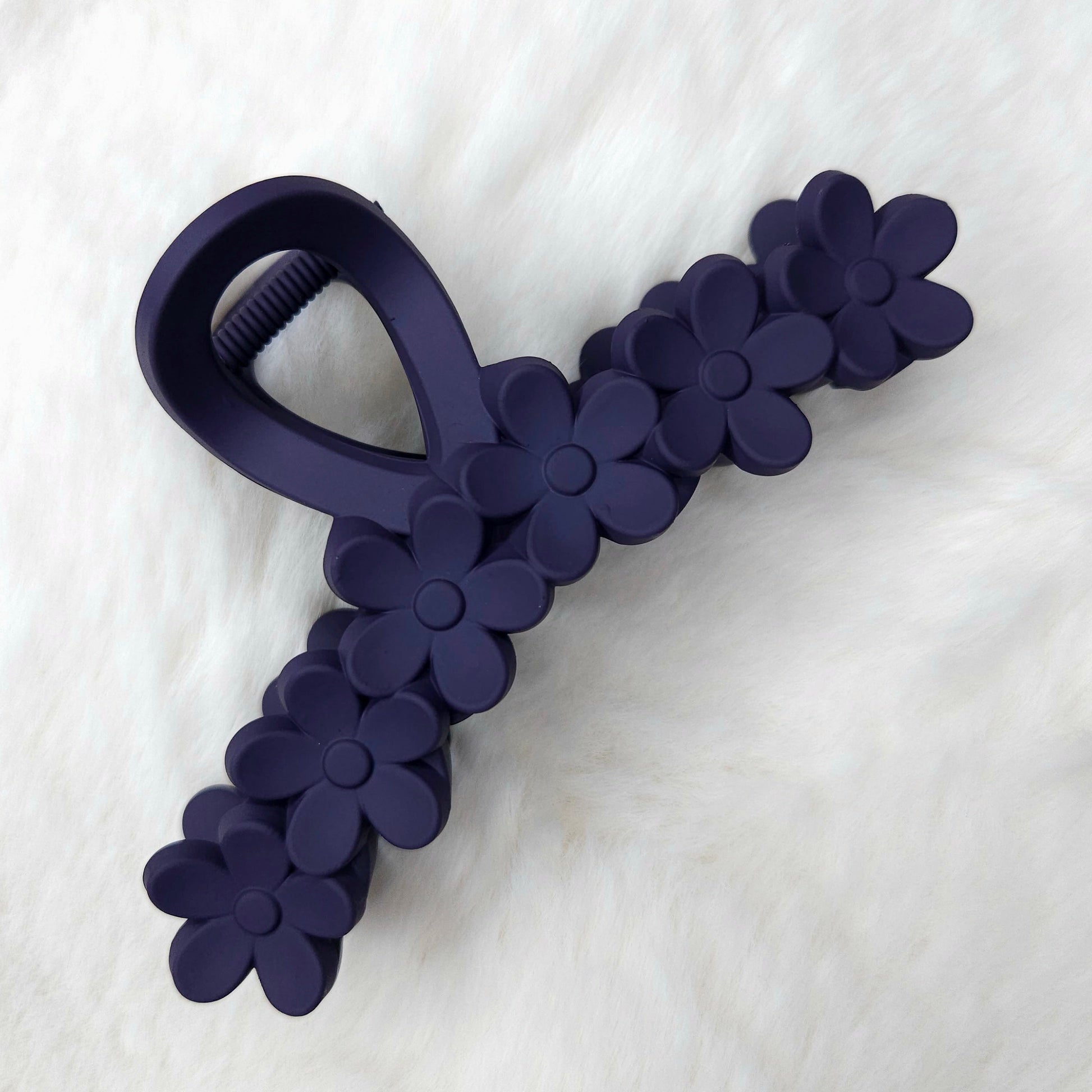 Navy blue flower-shaped tool on a white fabric background