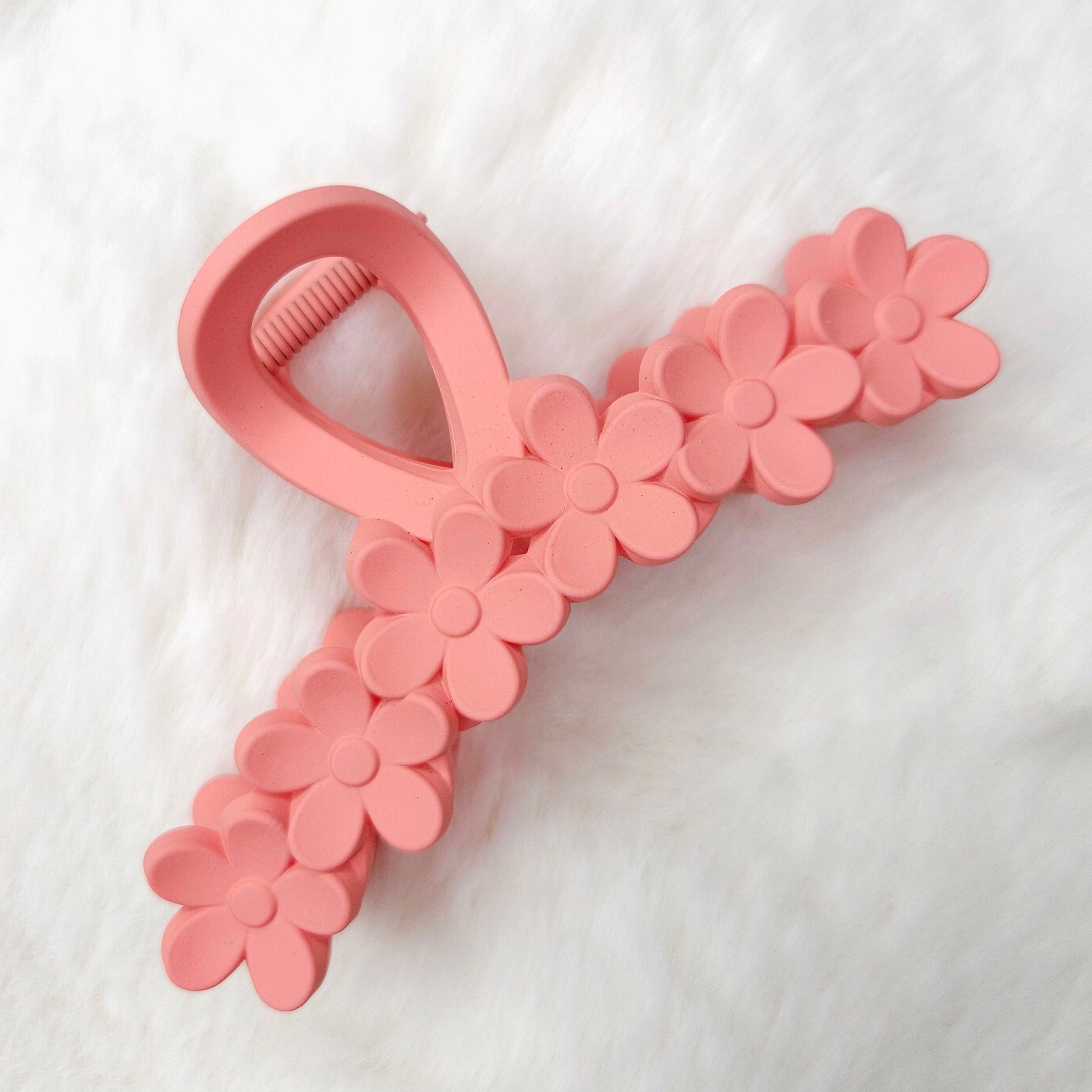 Pink hair claw clip with floral details on a white background