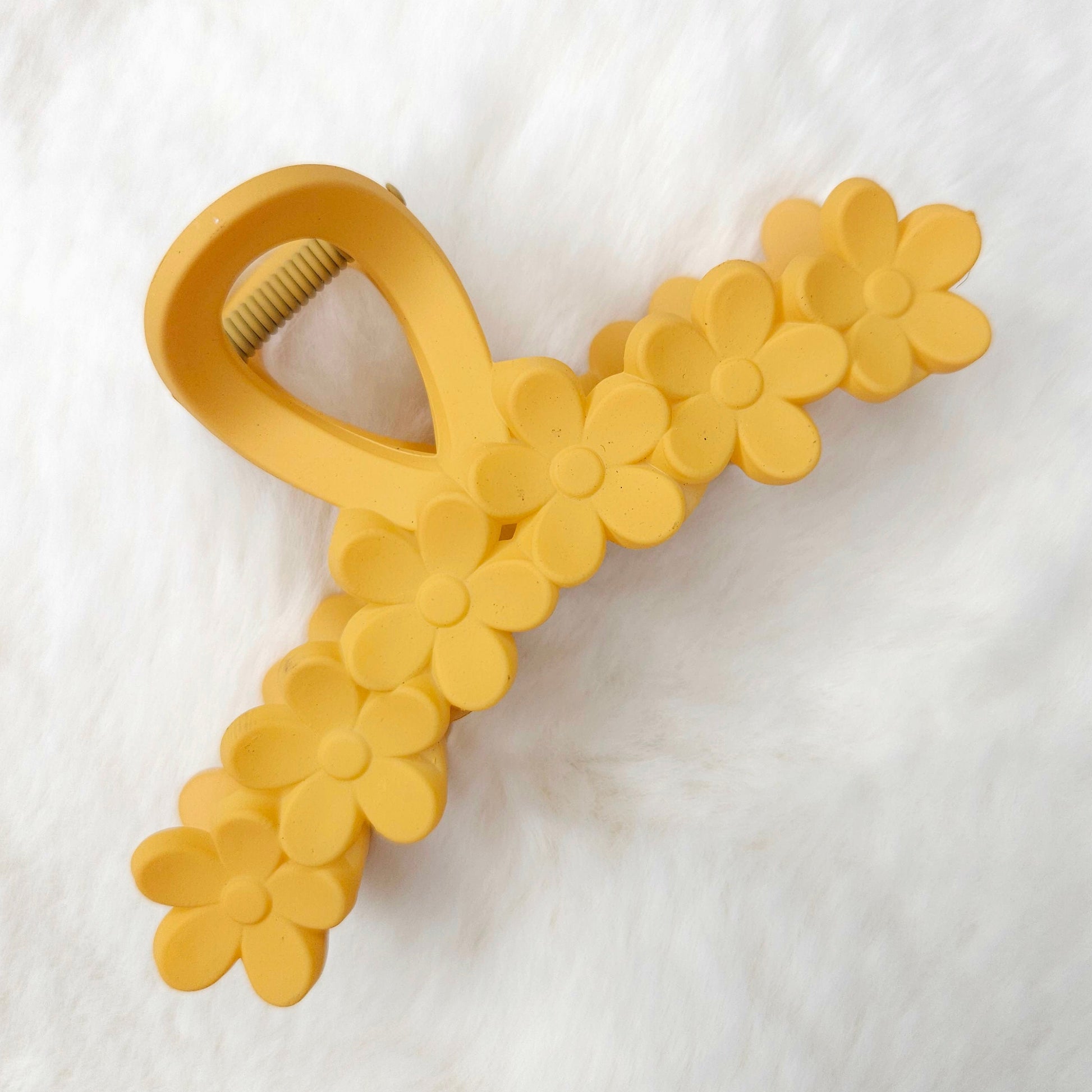 Yellow flower-shaped hair claw on a white background