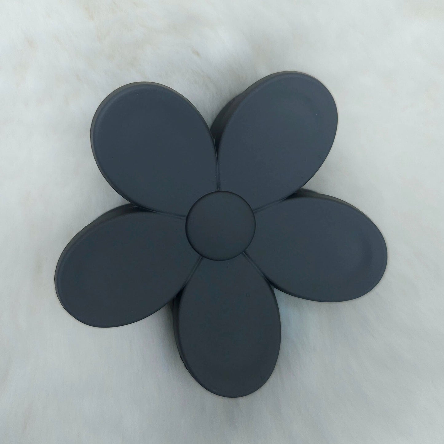 Black flower-shaped hair claw on a light gray background