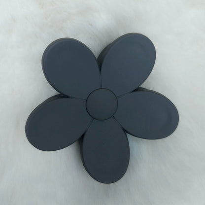 Black flower-shaped hair claw on a light gray background