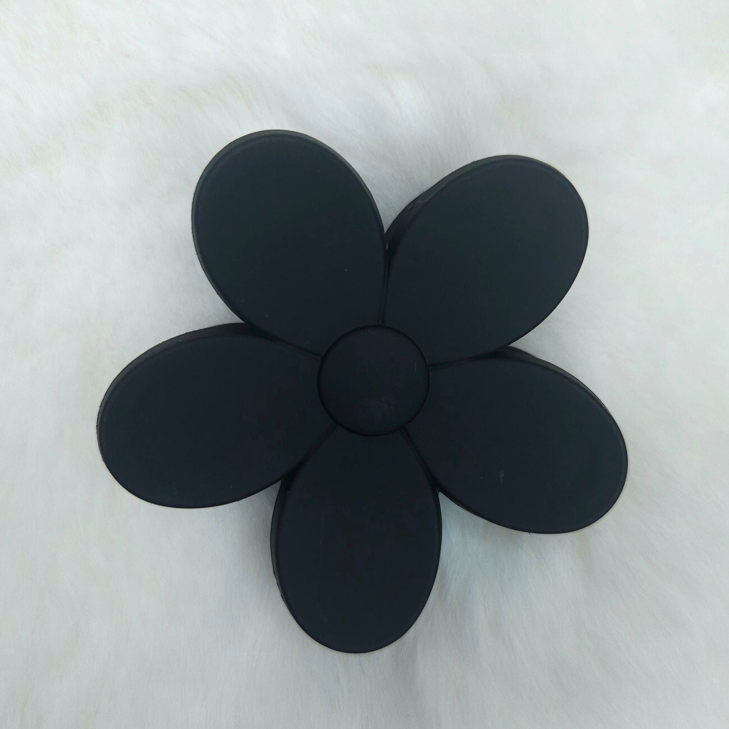 Black flower-shaped hair claw on a white background