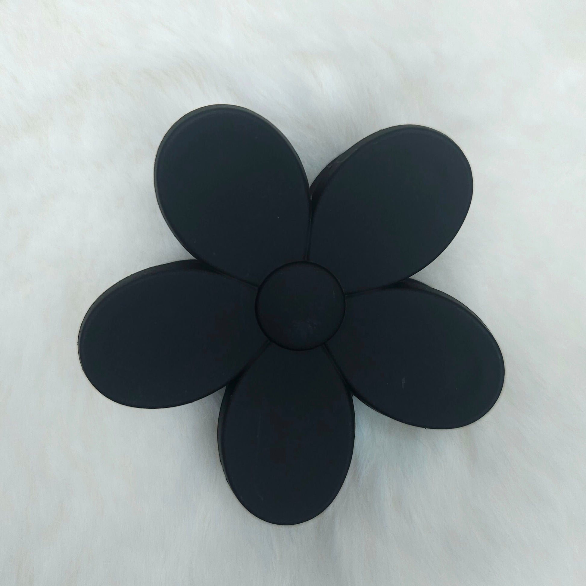 Black flower-shaped hair claw on a white background