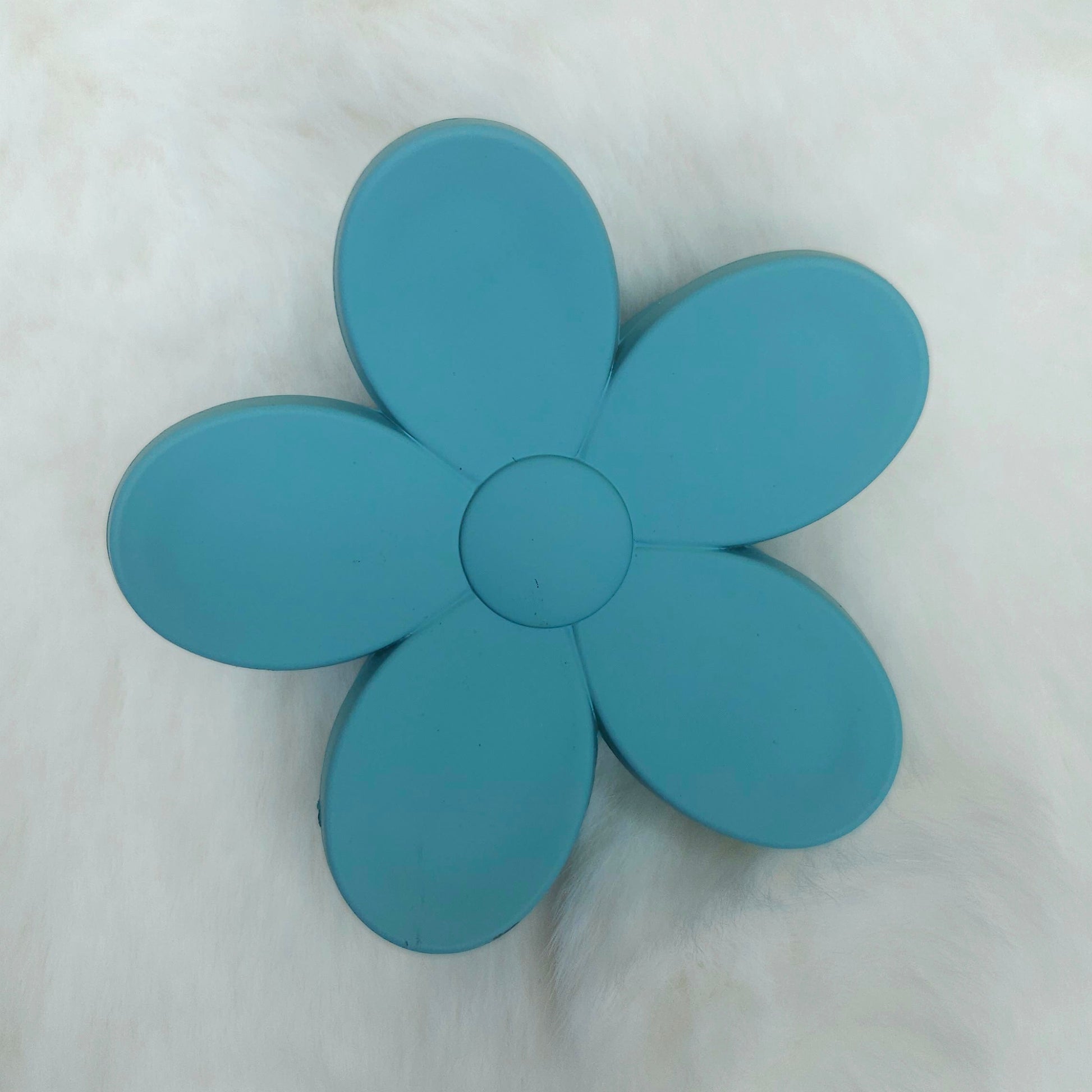 Blue flower-shaped hair claw on a white background