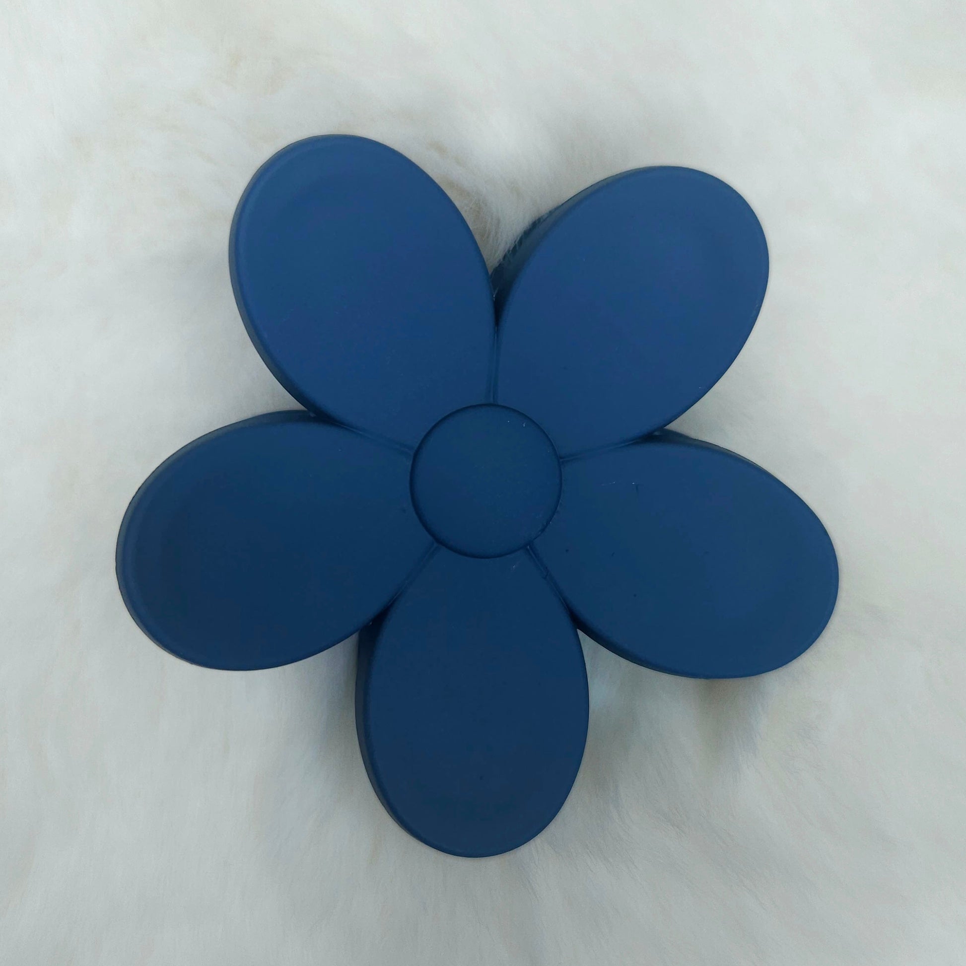 Blue flower-shaped hair claw on a white background