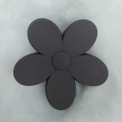 Black flower-shaped hair claw clip on a light gray background
