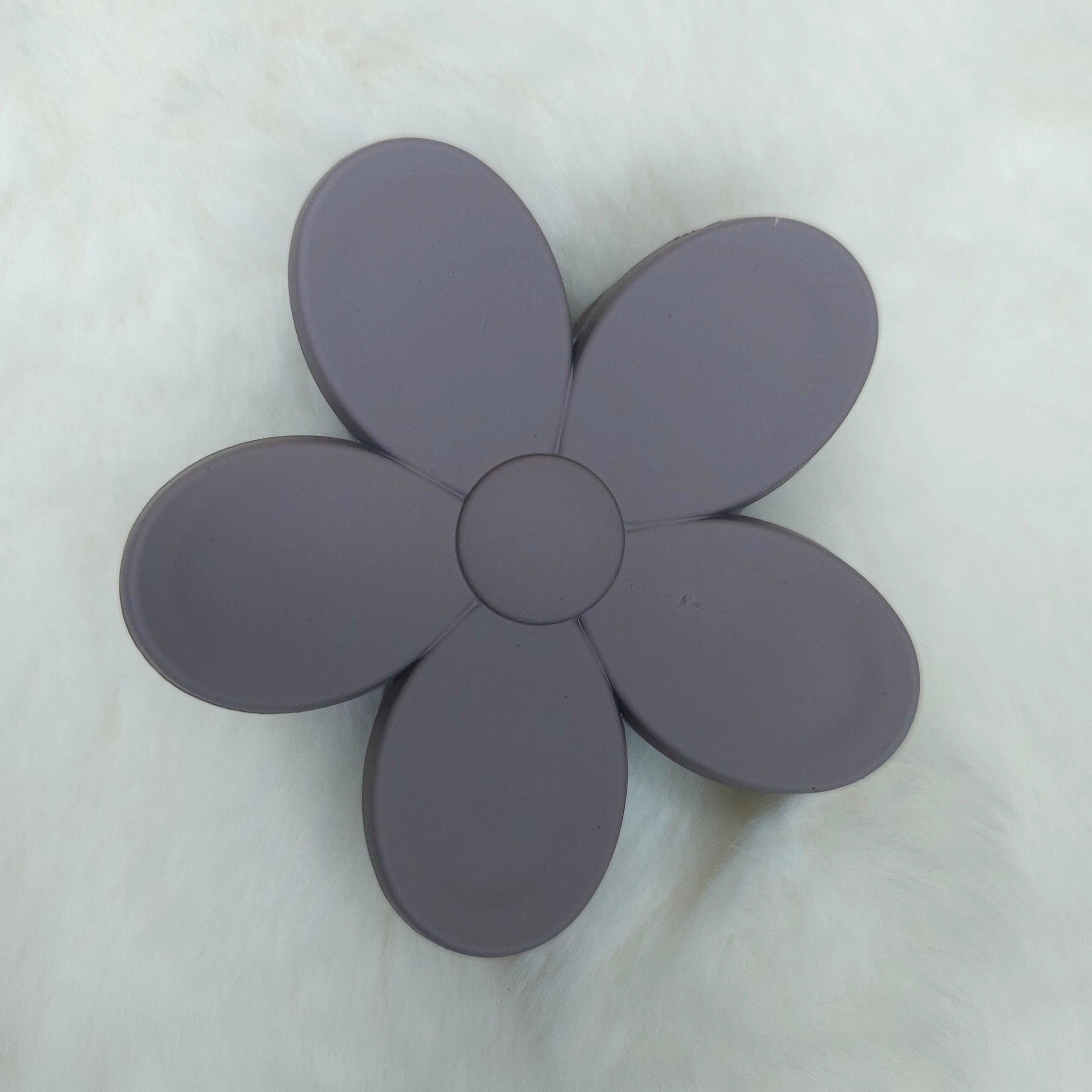 Flower-shaped hair claw with five petals on a light gray background