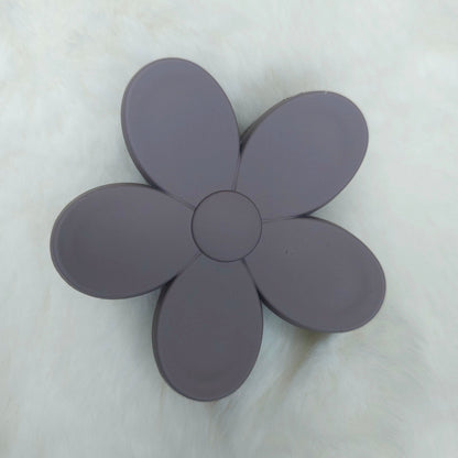 Flower-shaped hair claw with five petals on a light gray background