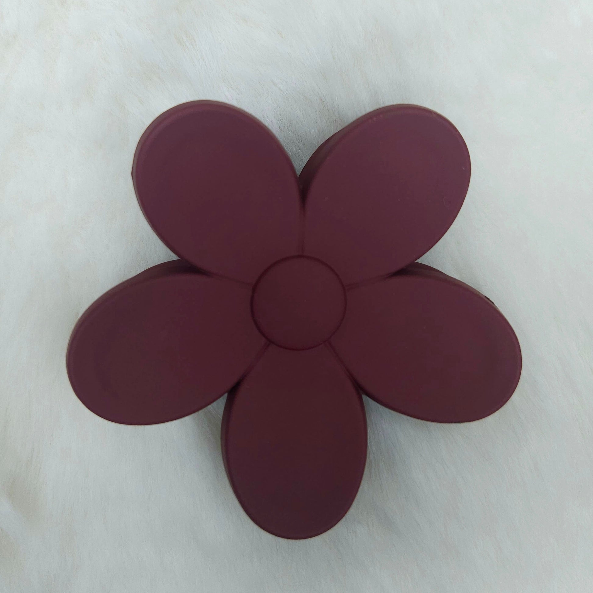 Maroon flower-shaped hair claw on a white background