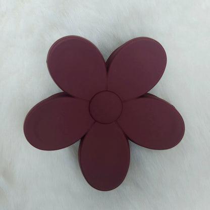 Maroon flower-shaped hair claw on a white background