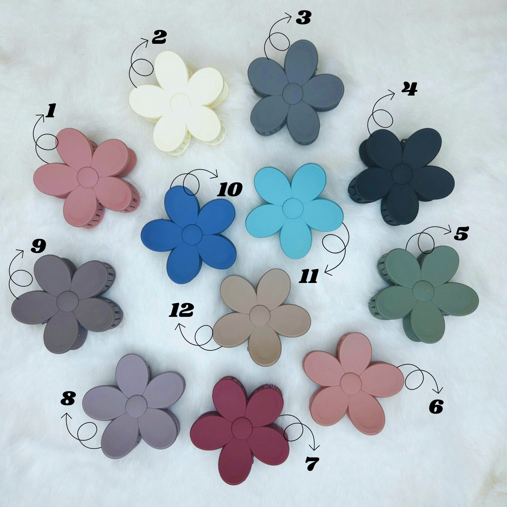 Assorted flower-shaped hair claws in various colors on a white background