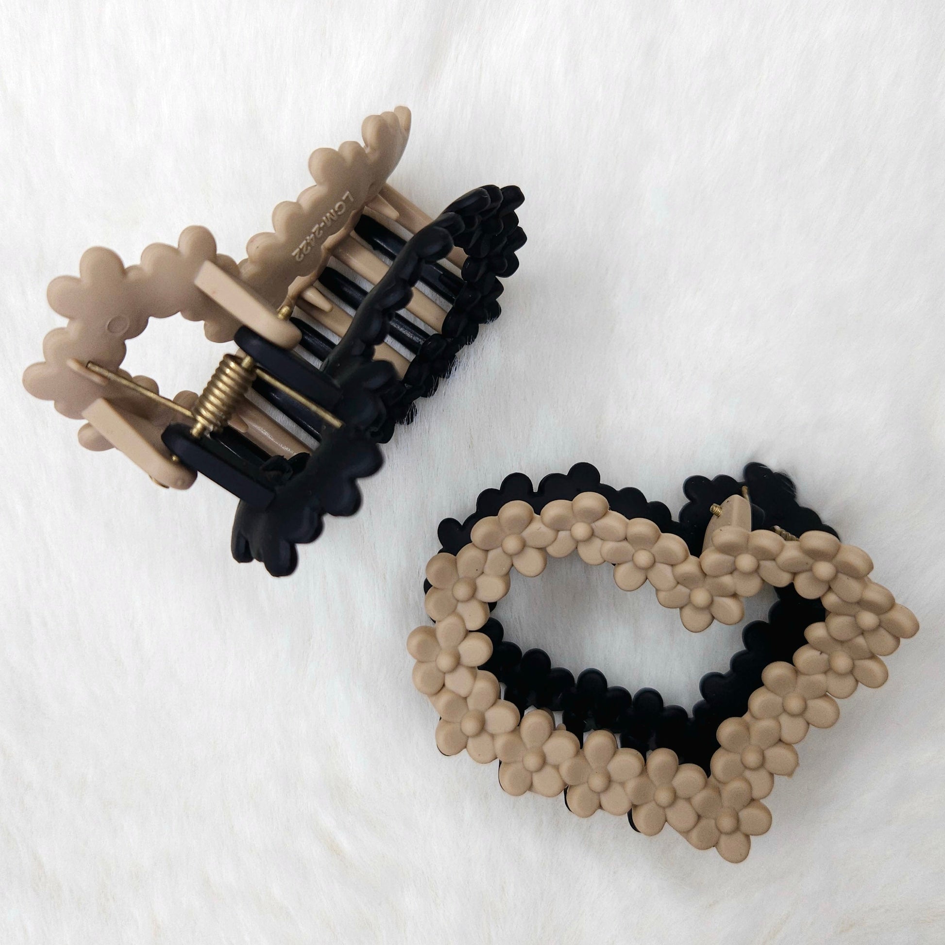 Heart-shaped hair clip with black and beige design on a white background