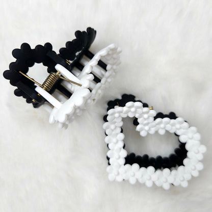 Black and white beaded hair claw clip on a light gray background