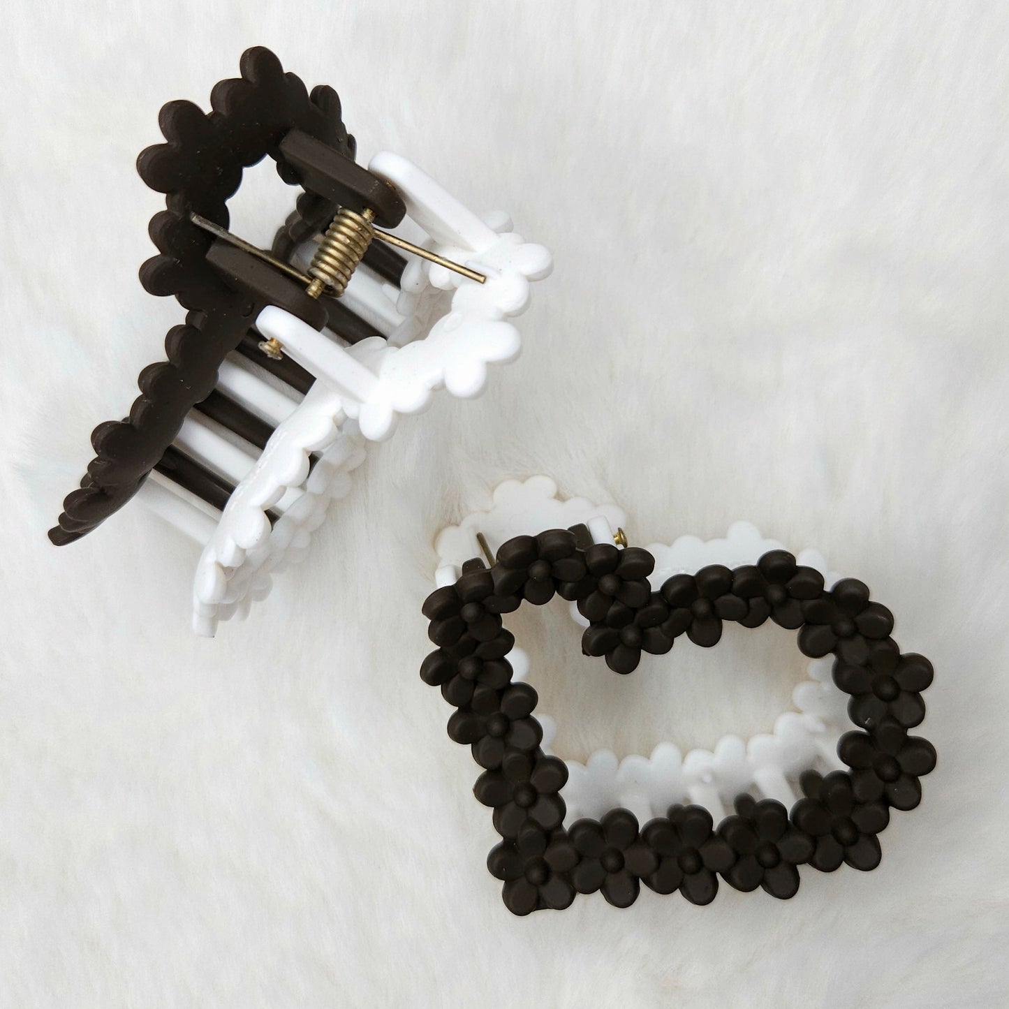 Black and white hair clip and beaded hair claw on a white background