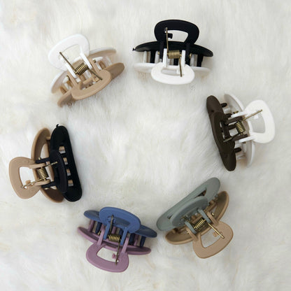 Set of colorful hair clips arranged in a circle on a white background