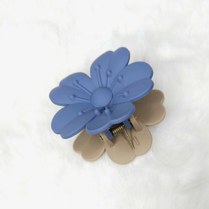 Blue and beige flower-shaped hair clip on a white background