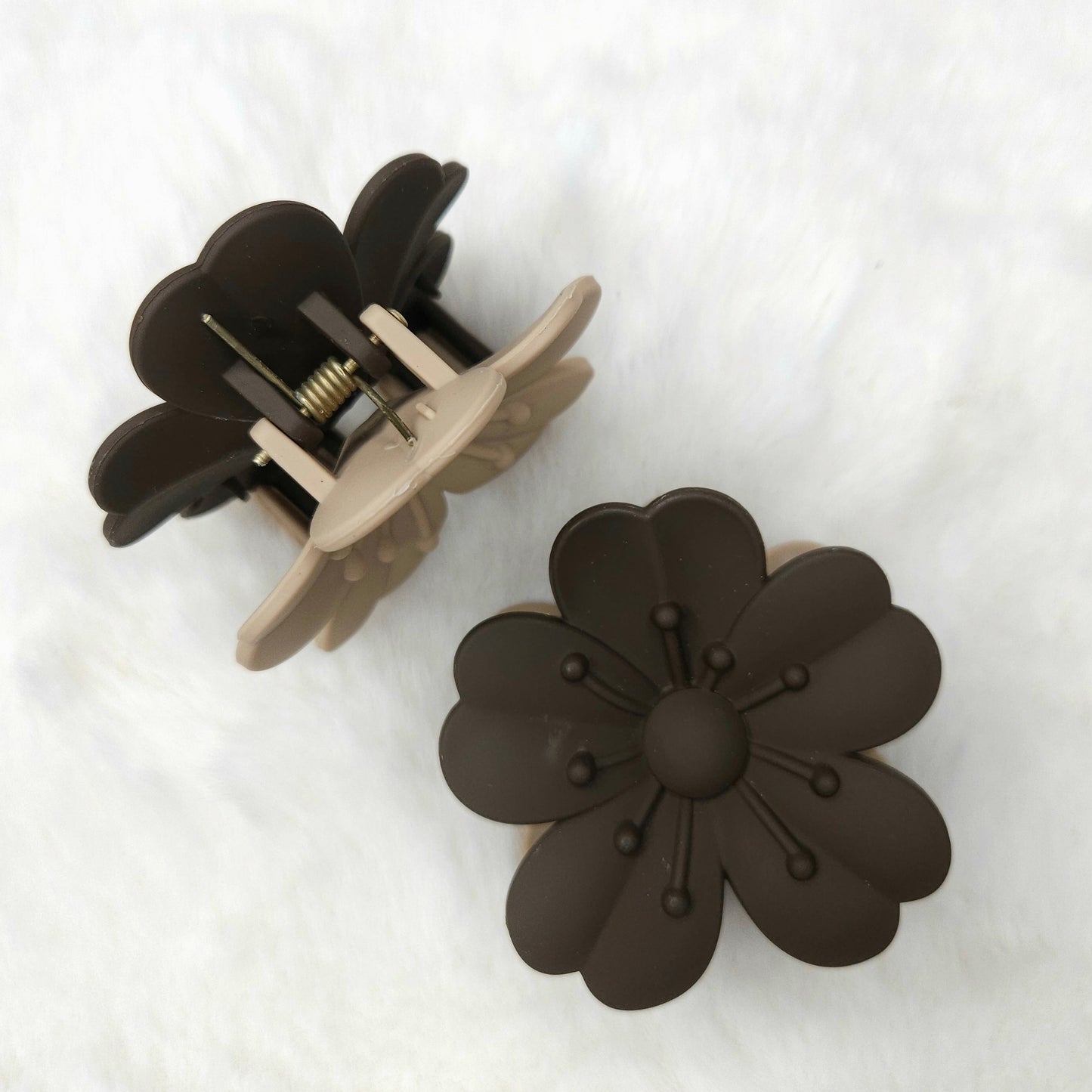 Floral-shaped gray-beige hair claw clips on a white background