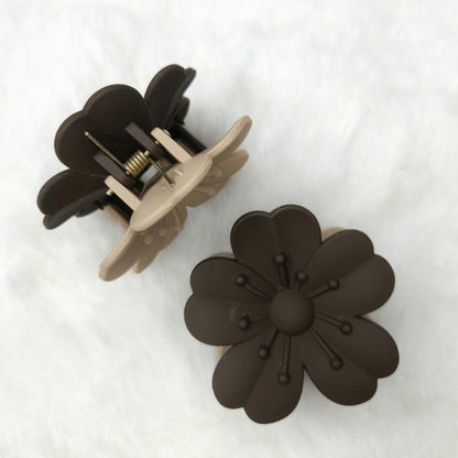 Floral-shaped gray-beige hair claw clips on a white background