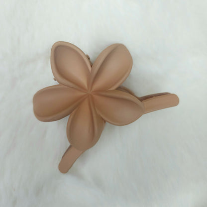 Brown flower-shaped hair clip on a white background