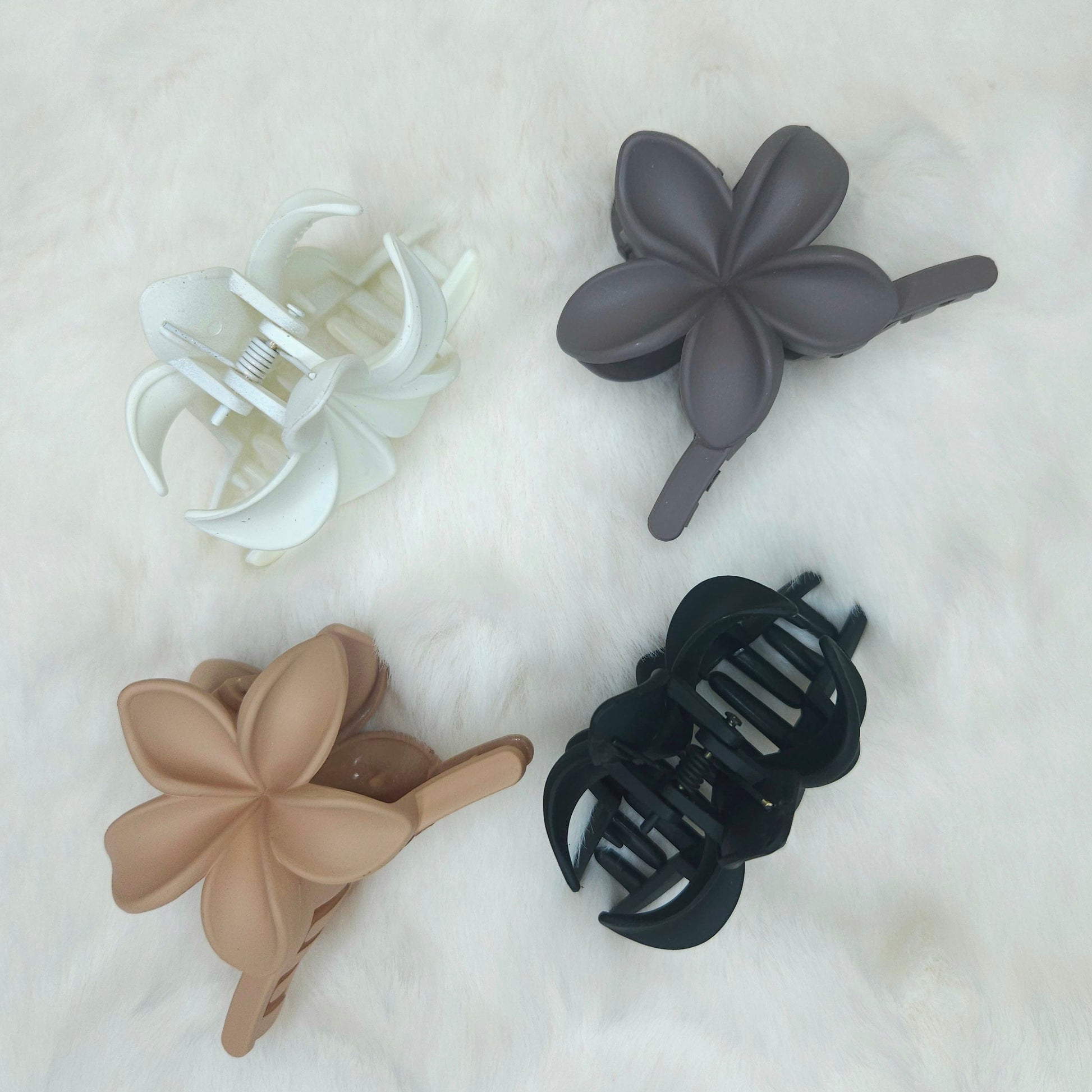 Four hair clips in different colors on a light background
