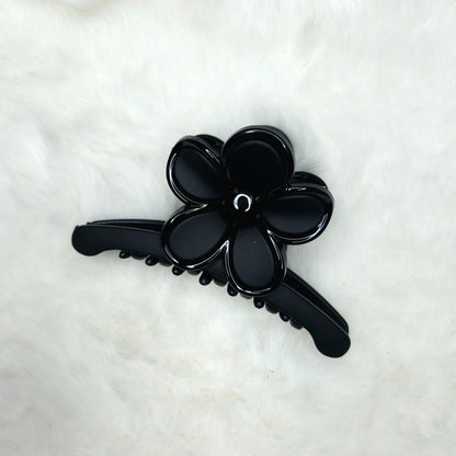Black flower-shaped hair claw clip on a white background