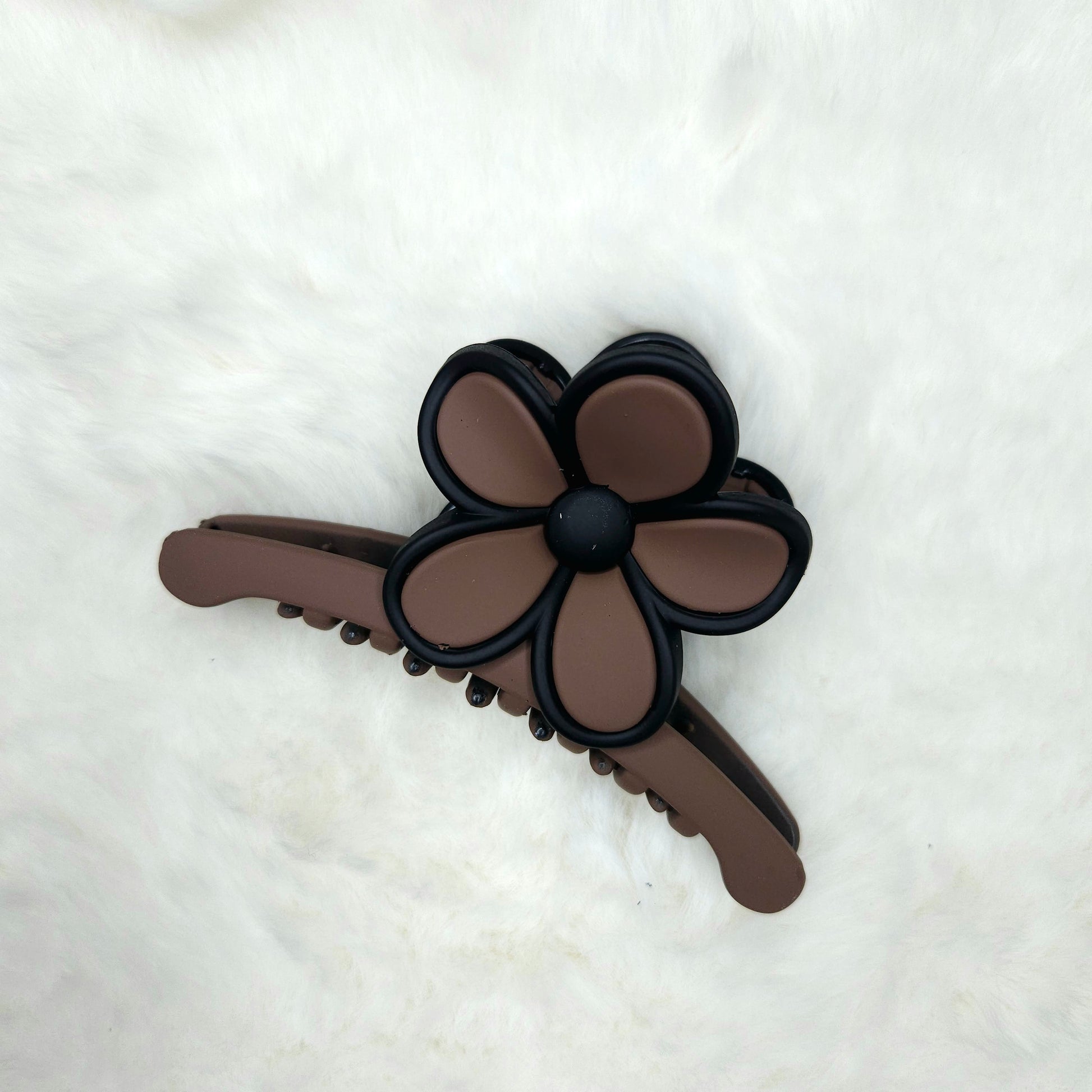Brown hair claw clip with flower design on a white background