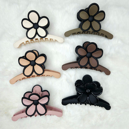 Set of six floral hair clips in various colors on a white background