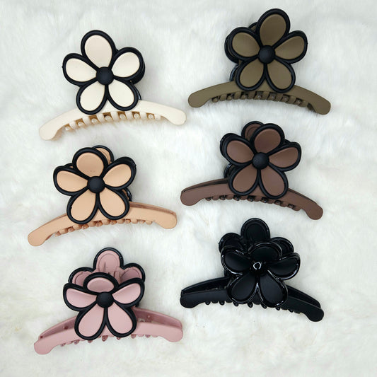 Set of six floral hair clips in various colors on a white background