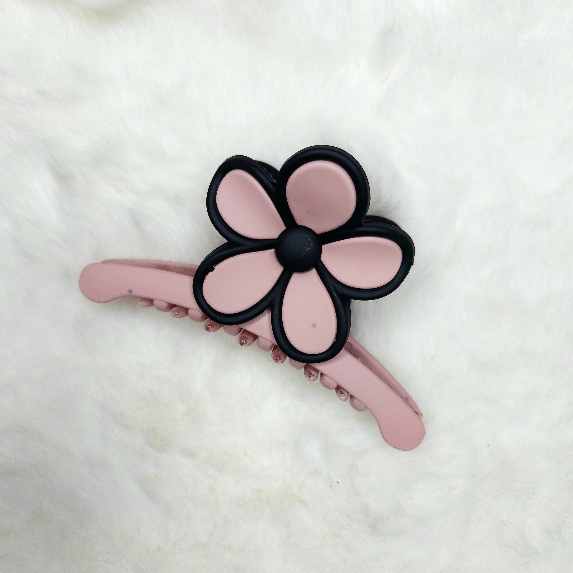 Pink flower-shaped hair claw clip on a white background