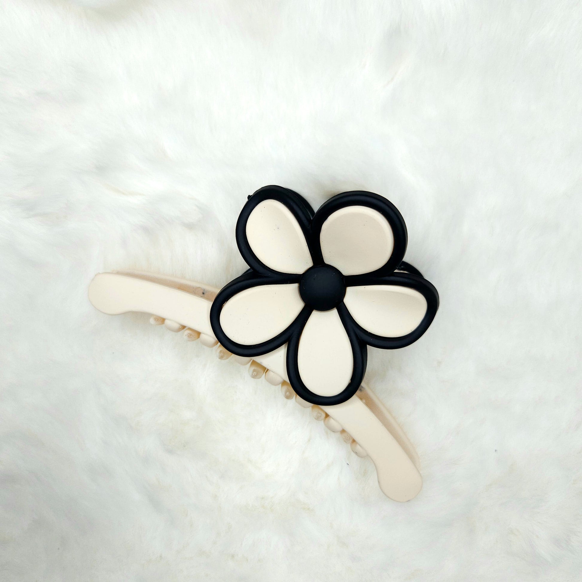 Hair clip with black and white flower design on a white background