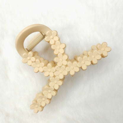 Beige floral-patterned loop shaped hair claw clip on a white background