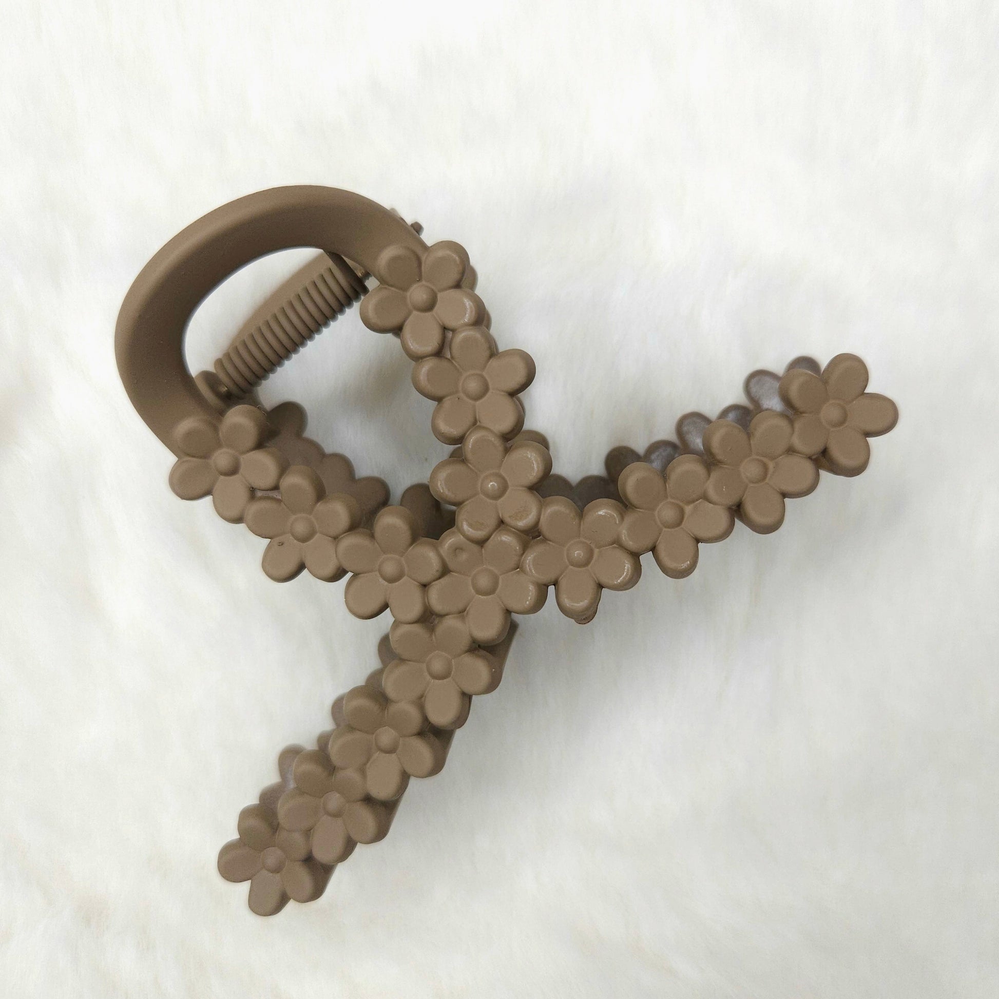 Light brown floral-patterned hair claw clip on a white background