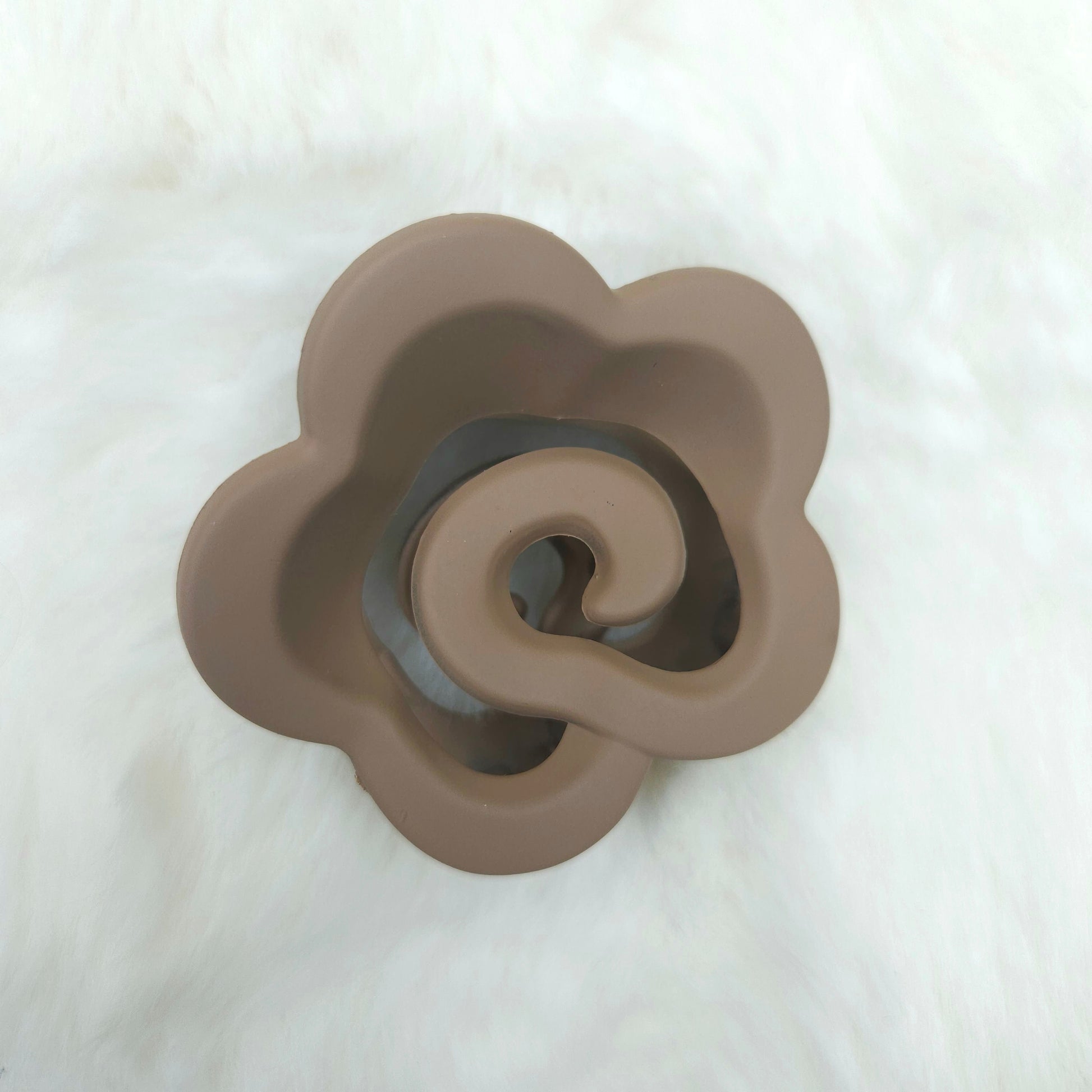 Brown ceramic flower-shaped hair claw on a white background