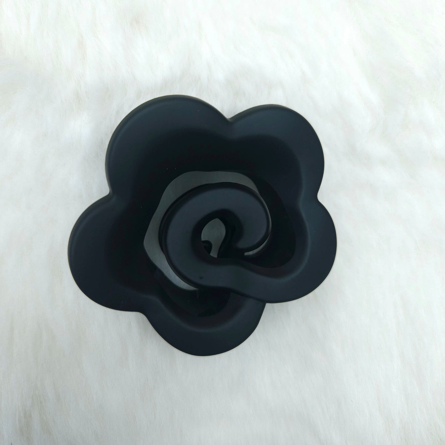 Black rose-shaped hair claw on a white background