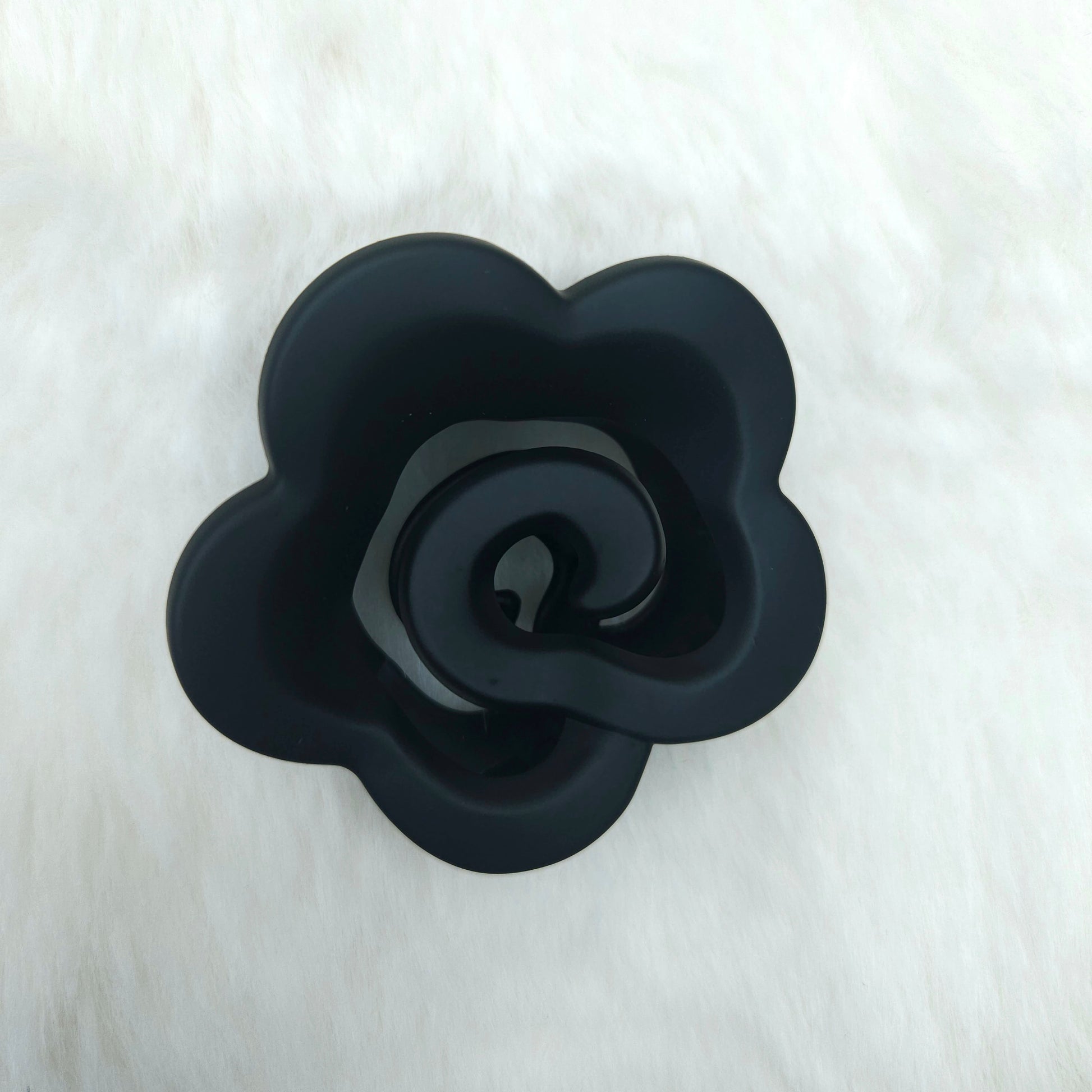Black rose-shaped hair claw on a white background