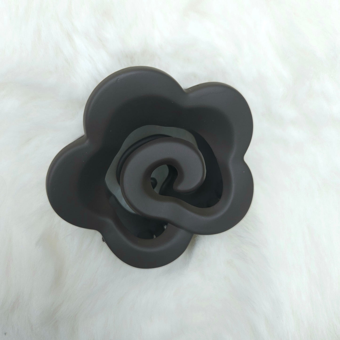 Black rose-shaped hair claw on a white background