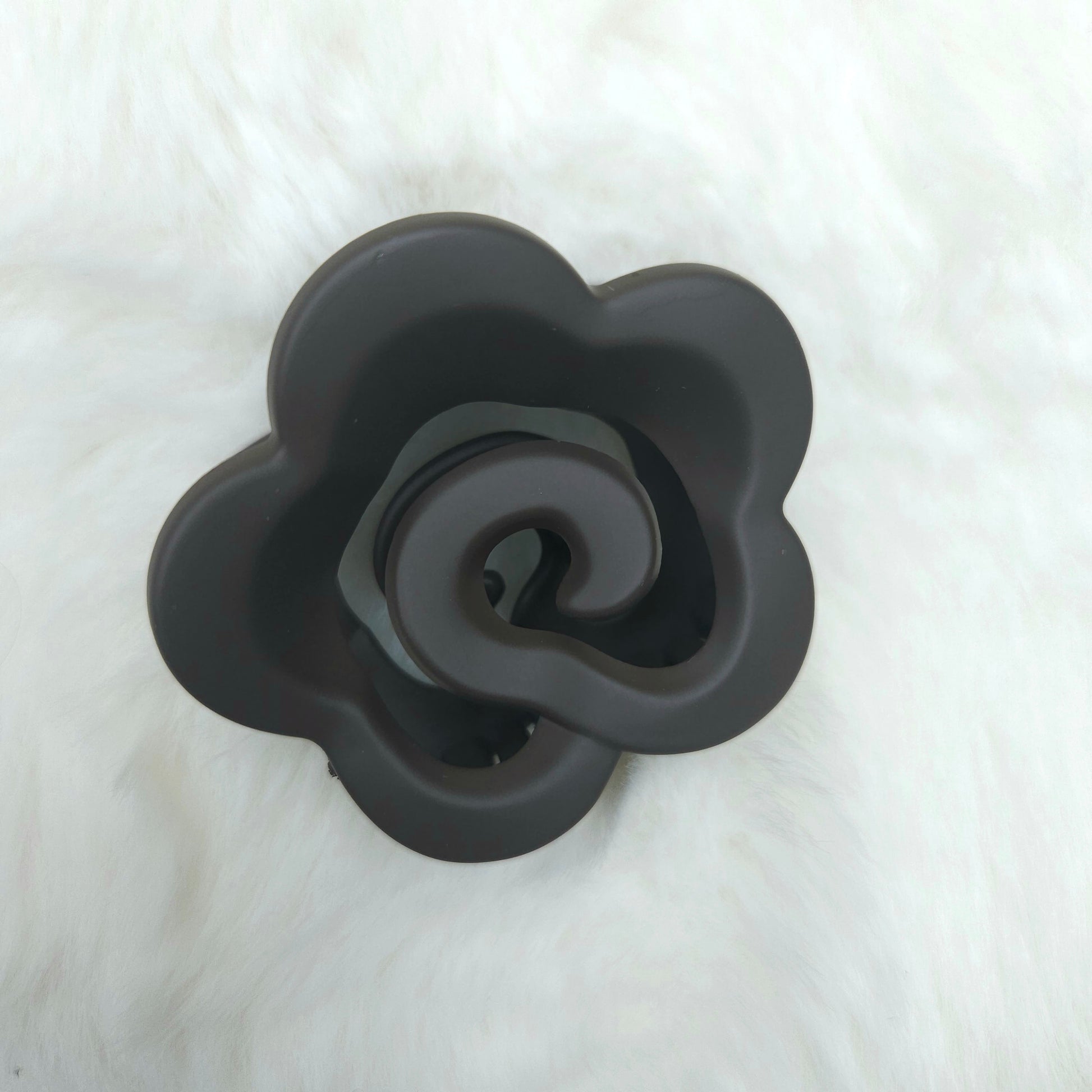 Black rose-shaped hair claw on a white background