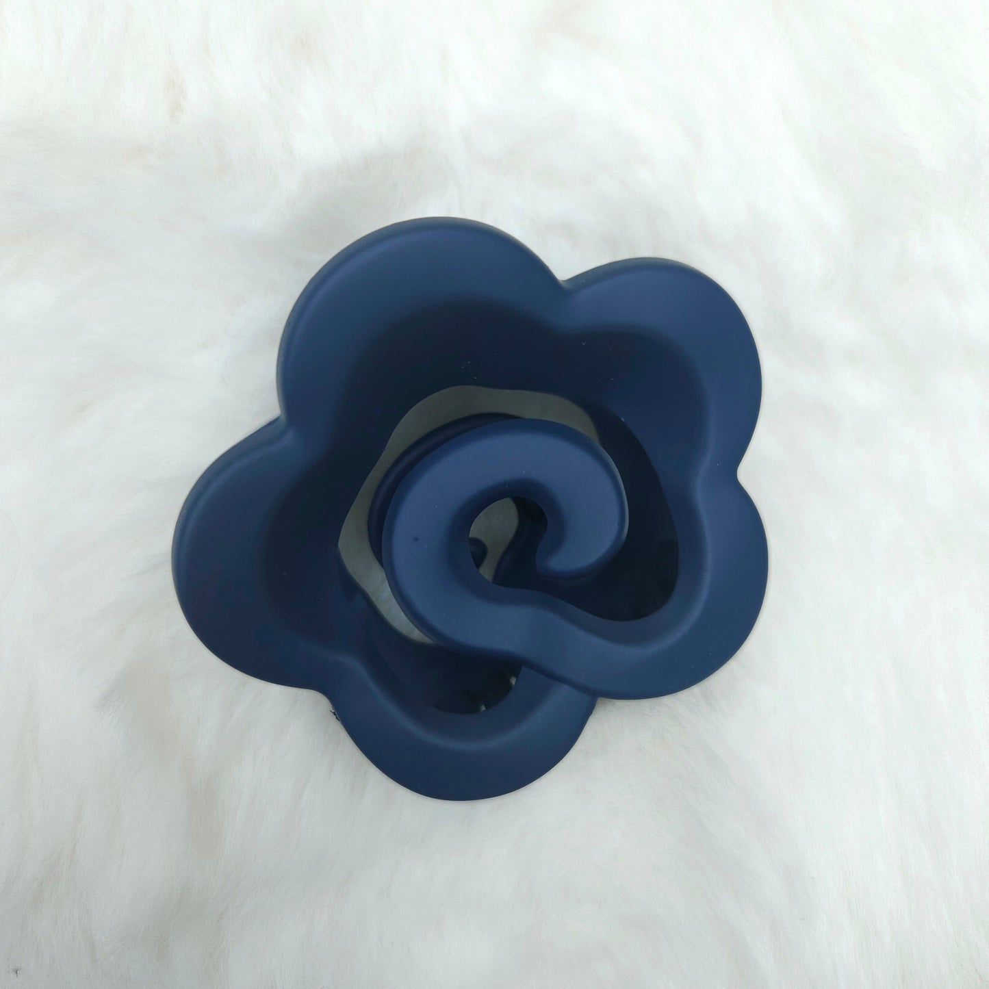 Blue silicone flower-shaped hair claw on a white background