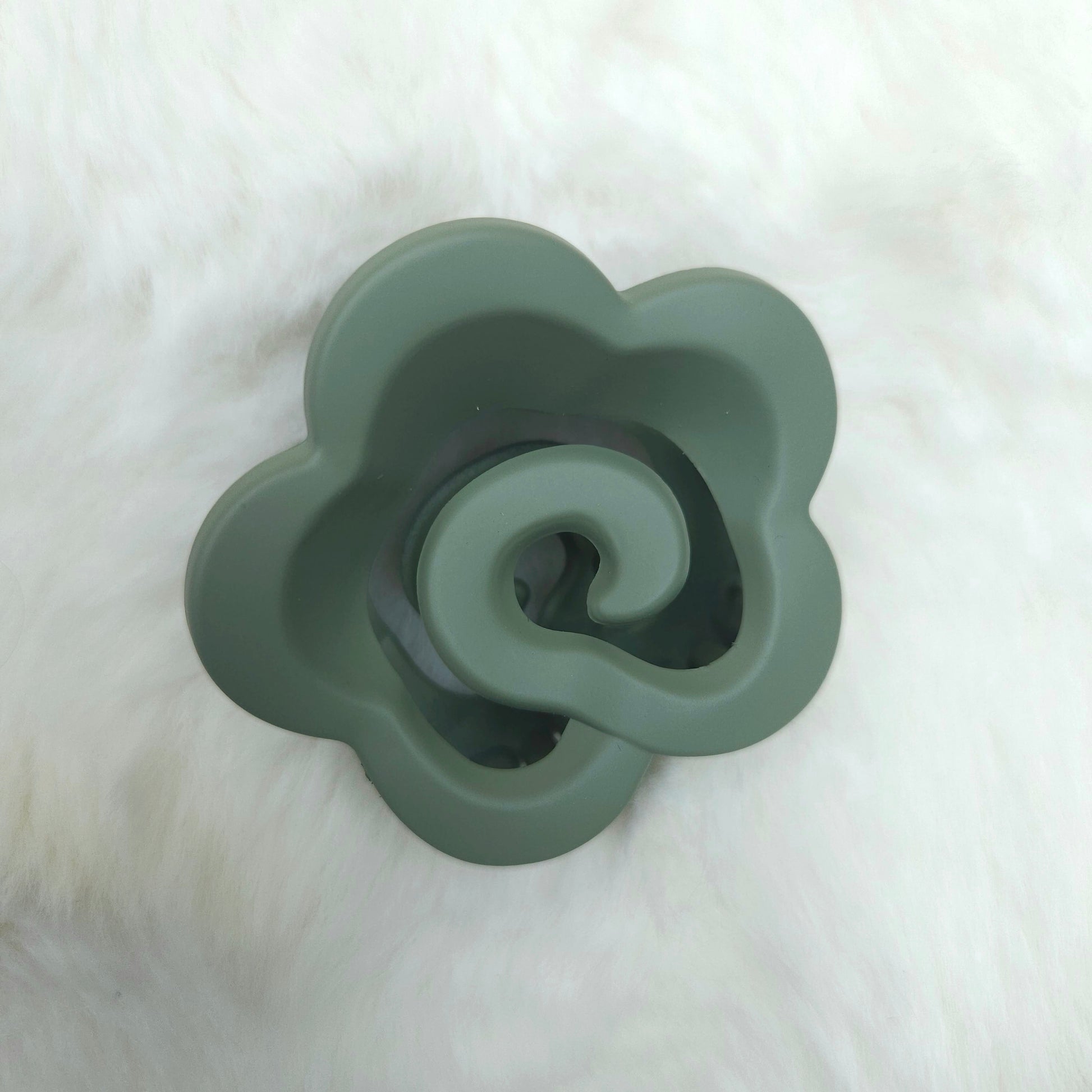 Green silicone flower-shaped hair claw on a white background