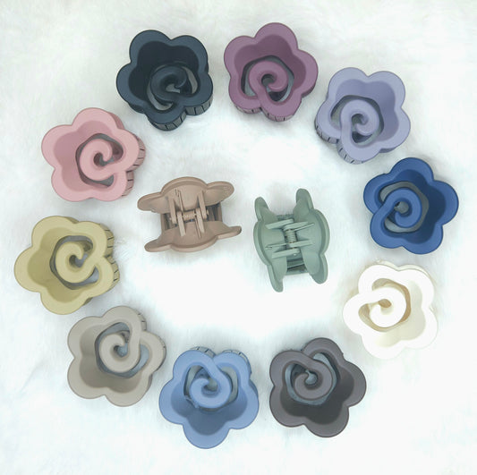 Set of colorful flower-shaped hair clips on a white background
